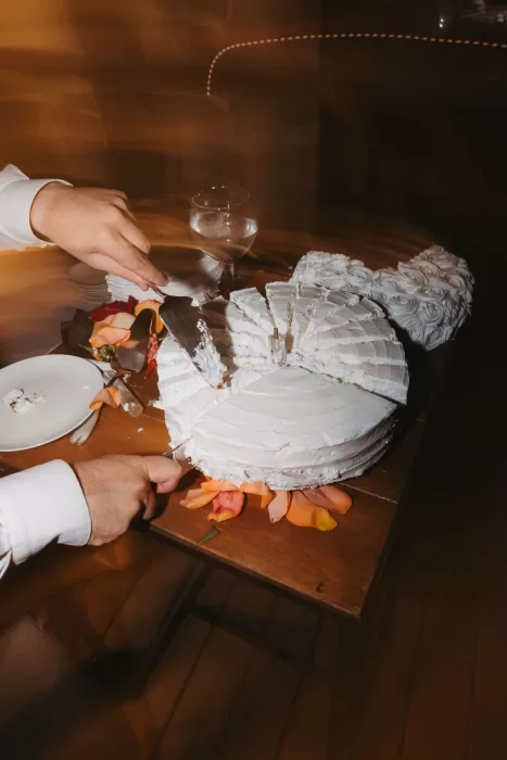 Wedding cake being sliced and served late into the evening at Masia Casa del Mar.
