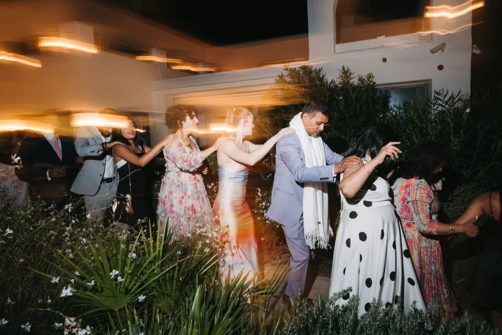 Guests in a joyful conga line winding through the garden at Masia Casa del Mar.