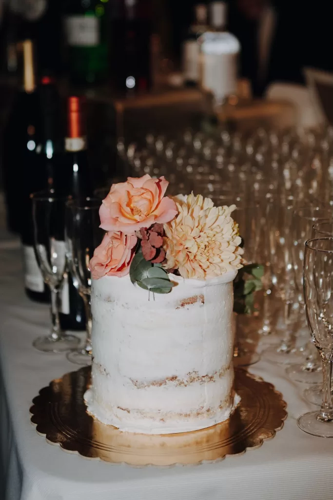 Single-tier semi-naked wedding cake with fresh flowers, ready to be served at Podere Calvaiola.