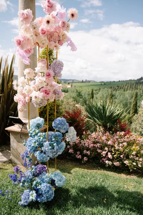 Statement wedding floral installation in pastel pink and blue at Tenuta Corbinaia with scenic Tuscan countryside views.