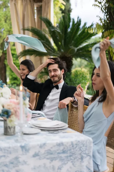 Wedding guests raising napkins in celebration during reception at Tenuta Corbinaia.