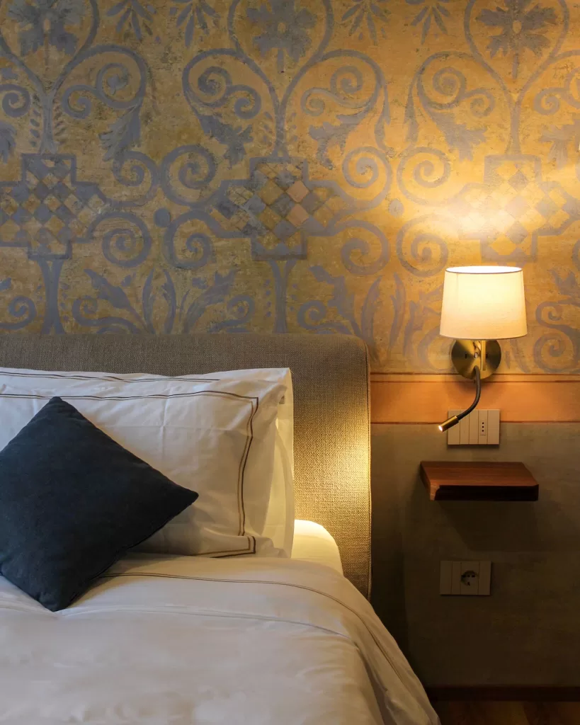 Warm and inviting bedroom at Villa Buttafava with elegant wall lighting and neutral-toned bedding.
