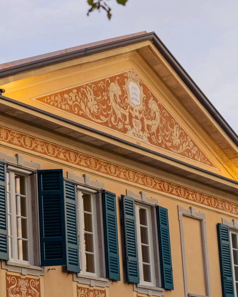 Decorative rooftop and painted pediment at Villa Buttafava, showcasing classical Italian villa architecture.