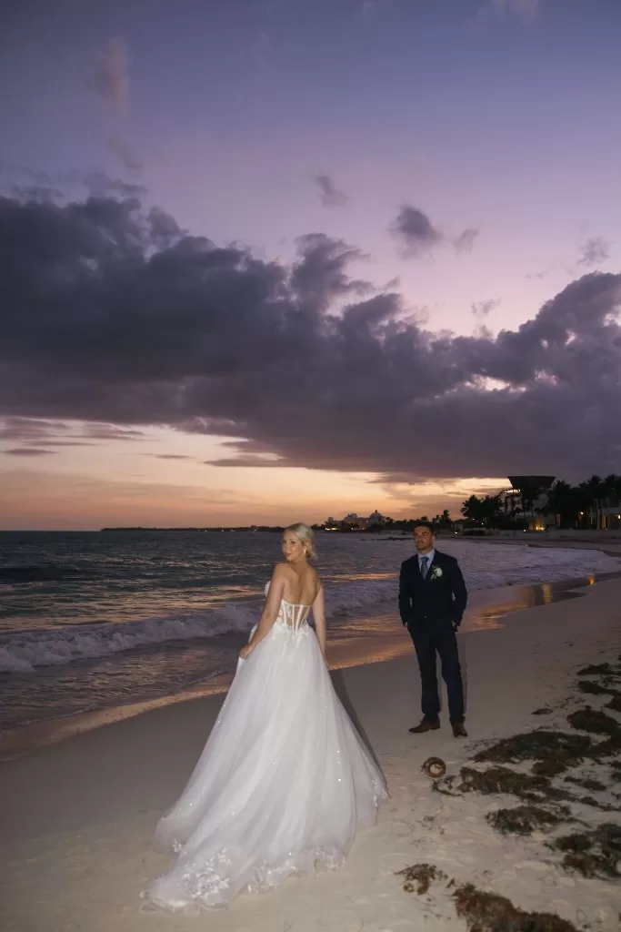Bride and groom on the beach at sunset with dramatic skies at Villa La Joya.