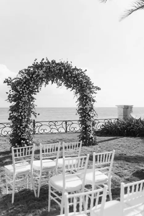 Romantic floral arch with ocean backdrop for ceremony at Villa La Joya.