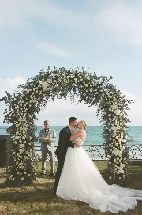 Romantic floral arch with ocean backdrop for ceremony at Villa La Joya.