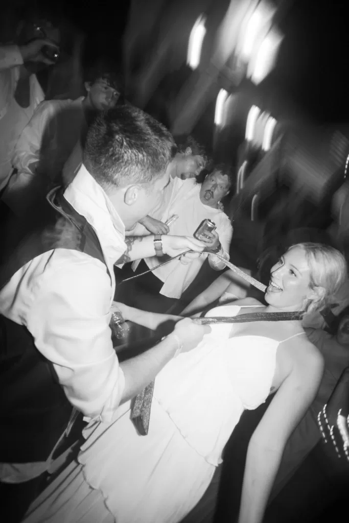 Wedding guests dance with energy at the Villa La Joya reception, captured in dynamic black and white.