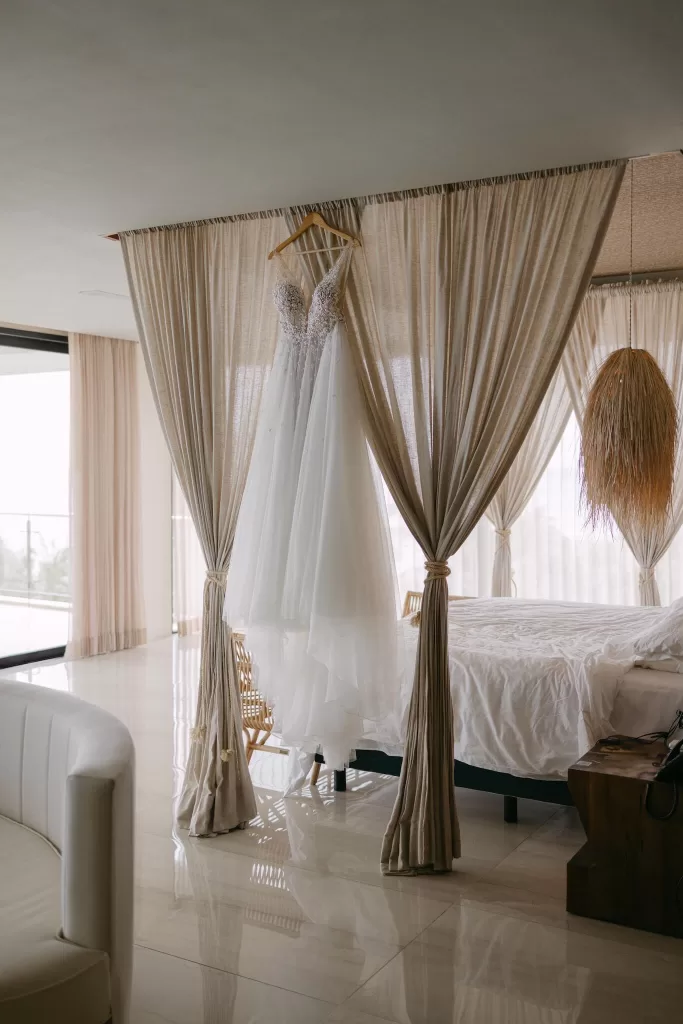 Bride’s wedding dress hanging gracefully in a sunlit suite at Villa La Joya.