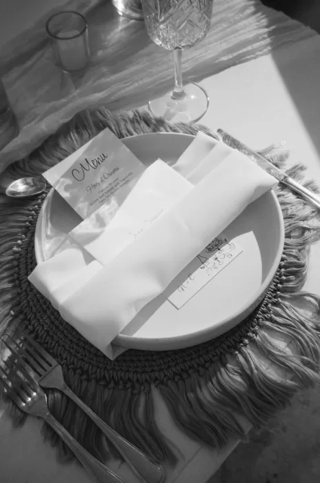 Elegant table setting with textured charger and custom menu card at Villa La Joya wedding dinner.