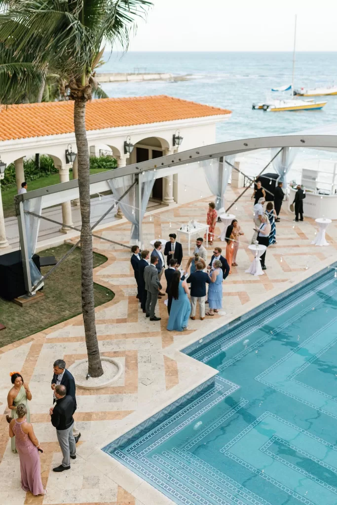 Wedding guests mingle by the oceanfront pool terrace at Villa La Joya with sweeping sea views.