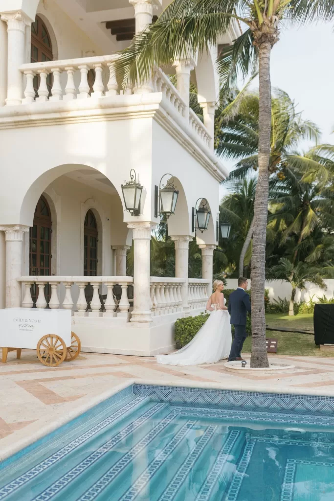 Bride and groom sharing a quiet moment near the pool under the grand arches of Villa La Joya.