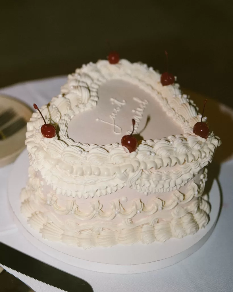Heart-shaped vintage-style wedding cake with piped icing and cherries served at Villa La Joya reception