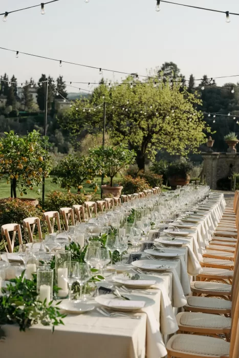Long banquet table beautifully set with greenery and candles under string lights at Villa Medicea di Lilliano.
