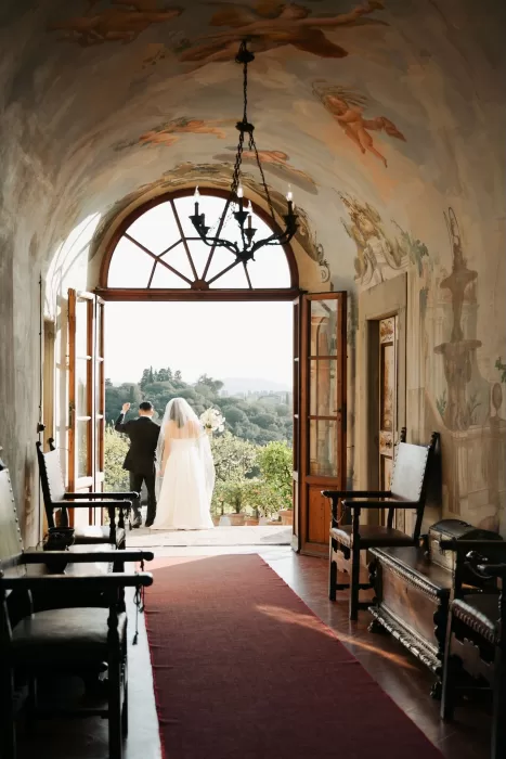Bride and groom exiting into the villa gardens after their ceremony at Villa di Maiano.