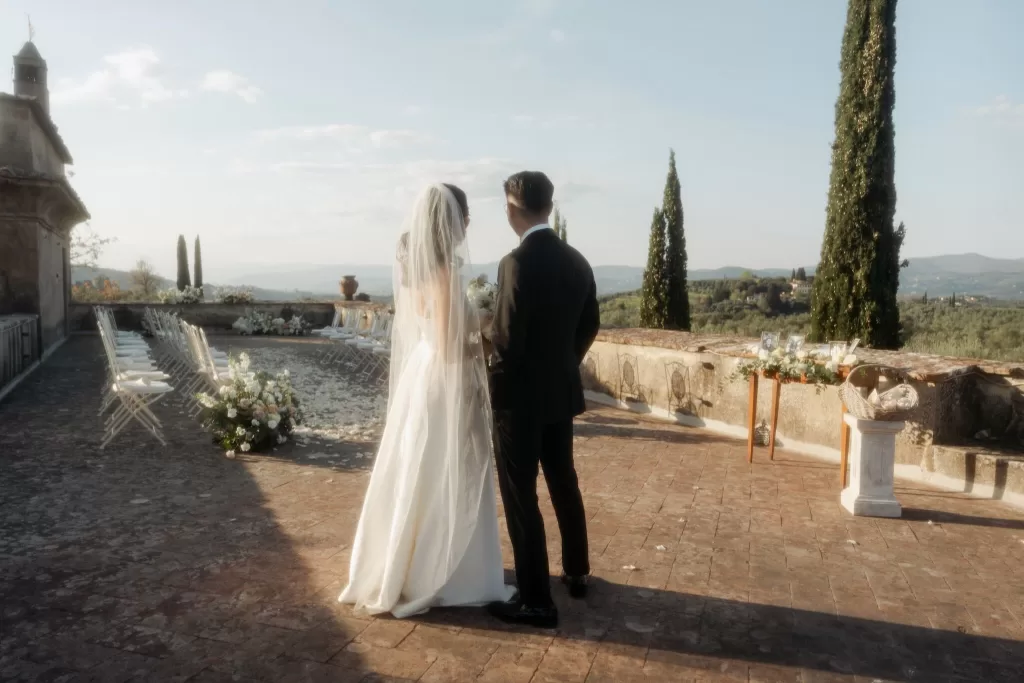 Wedding ceremony chairs and floral aisle decor under the Tuscan sun at Villa di Maiano.