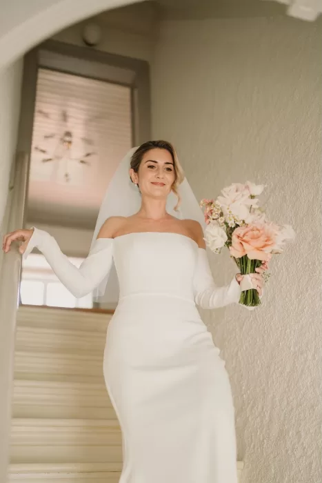 Bride walking down whitewashed staircase at Casa Sacoto