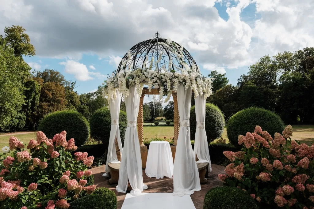 Groom walking confidently down a manicured path toward Château Challain’s grand façade.