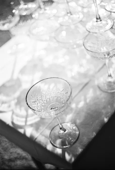 Crystal champagne coupes catching the light on a wedding reception table at Château de la Couronne.