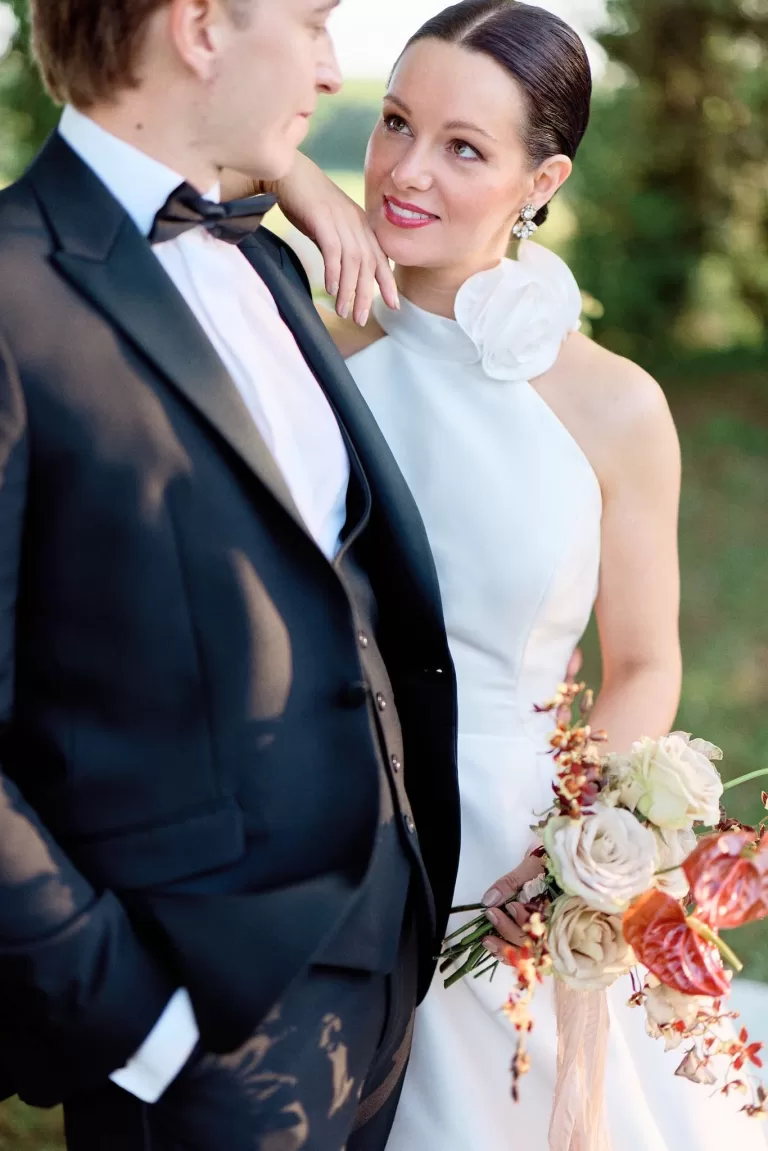 Bride gazing at groom with love, holding warm-toned bouquet at Chateau de Sanse.