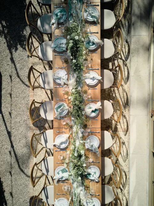 Overhead view of long reception table with lush green florals at Château de Sanse.
