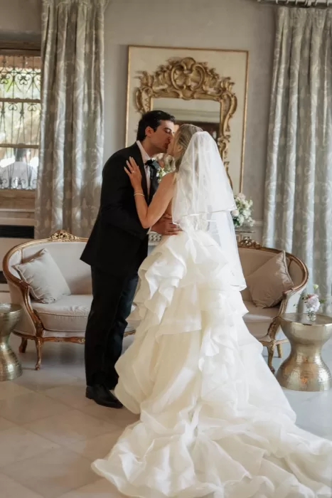 Newlyweds share a kiss in an elegant salon at Cigarral de las Mercedes.