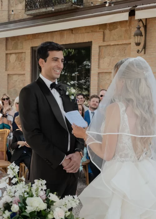 Bride reads her vows to the smiling groom during an outdoor ceremony at Cigarral de las Mercedes.