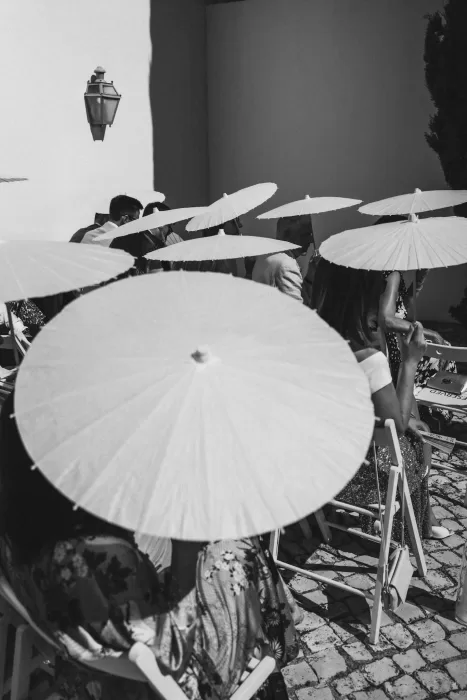 Wedding guests holding parasols during outdoor ceremony at Casa Sacoto