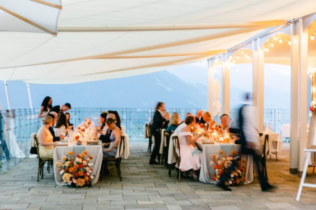 Intimate evening wedding dinner under fairy lights at Hotel Villa Honegg, with glowing candles and joyful guests.