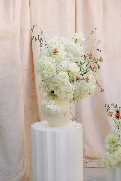 Cream and blush floral arrangement in a ceramic vase at Masia Cabellut wedding ceremony
