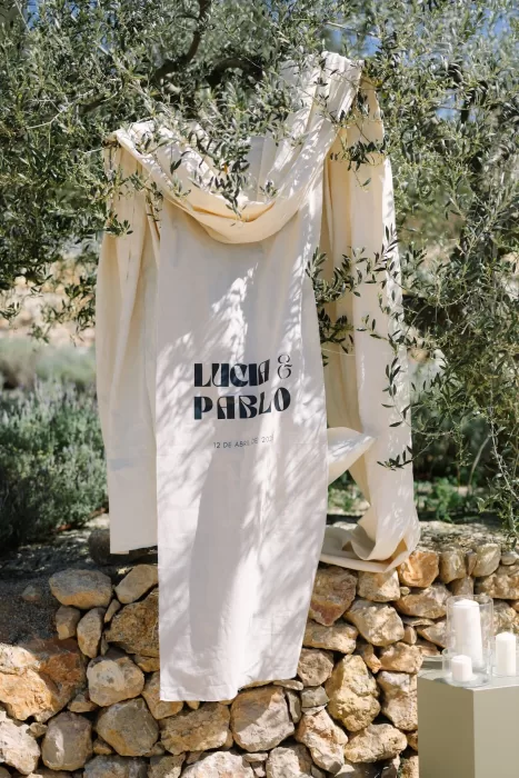 Custom wedding banner for Lucía and Pablo hanging from olive tree at Masia Cabellut