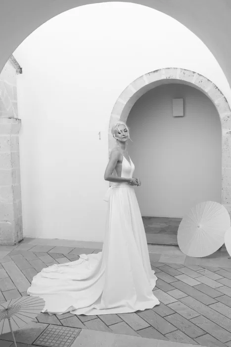 Bride posing beneath archway in elegant gown at Masseria San Giovanni