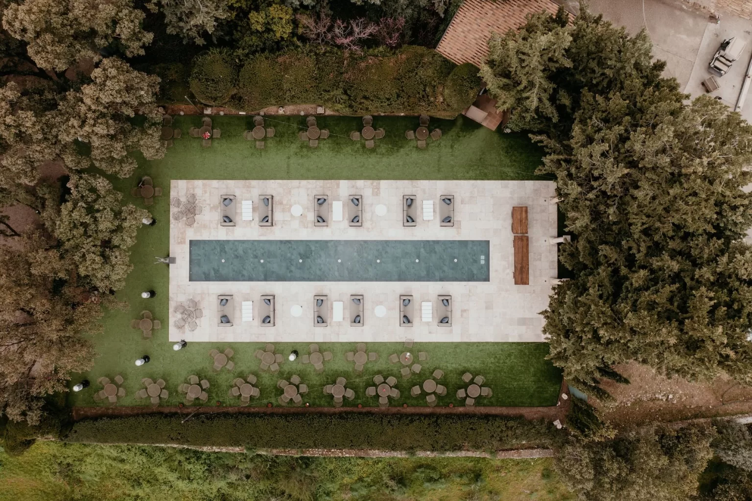 Aerial view of the modern pool area at Cigarral de las Mercedes, surrounded by trees and loungers.