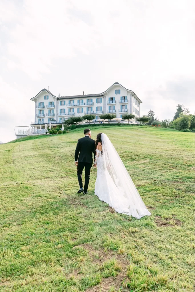 Bride and groom walking uphill toward Hotel Villa Honegg after their ceremony.