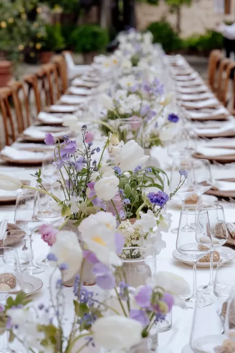 Pastel-toned floral arrangements with sweet peas and ranunculus along the wedding table at Borgo Sant'Ambrogio