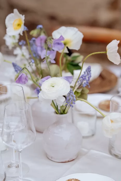 Delicate bud vase with white ranunculus and lilac blooms on the reception table at Borgo Sant'Ambrogio.