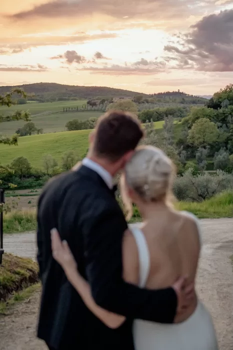 Bride and groom watching the golden sunset over the Tuscan hills at Borgo Sant'Ambrogio.