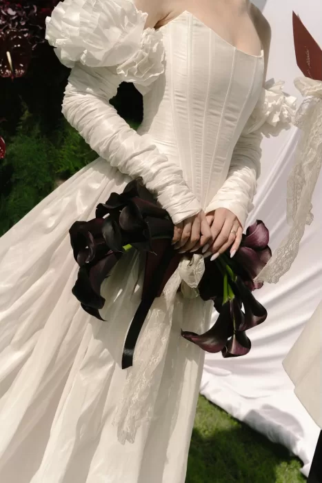 Close-up of bride’s calla lily bouquet tied with black ribbon at Treelove Parkas.