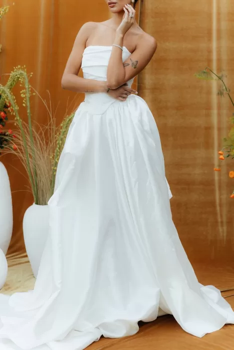 Bride in satin strapless gown poses against mustard velvet backdrop at The Bradford NC.