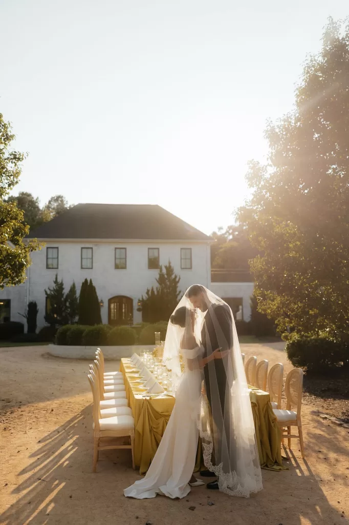 Bride and groom under veil at a golden hour reception setup at The Bradford NC