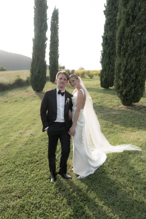 Romantic portrait of the bride and groom in the gardens of Casa Olivi, framed by cypress trees.