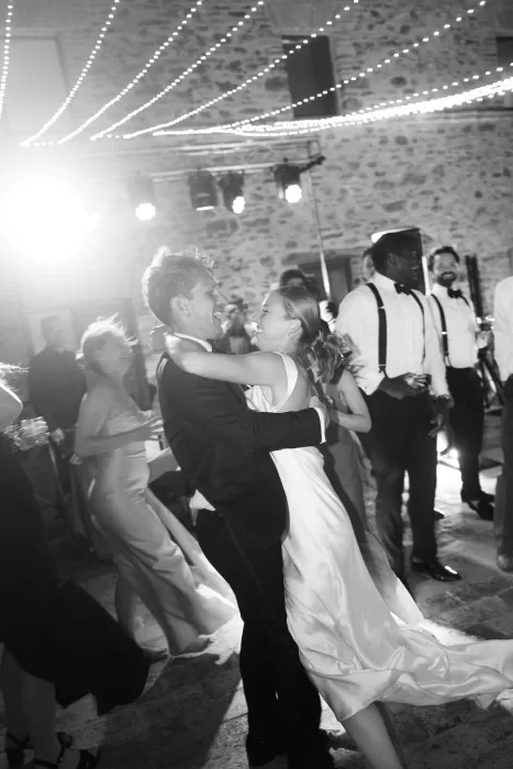 Joyful moment as the newlyweds dance surrounded by guests under twinkling lights at Casa Olivi.