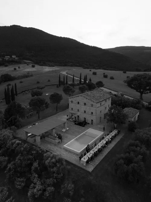 Black and white aerial photo of the long dinner table and poolside terrace at Casa Olivi.