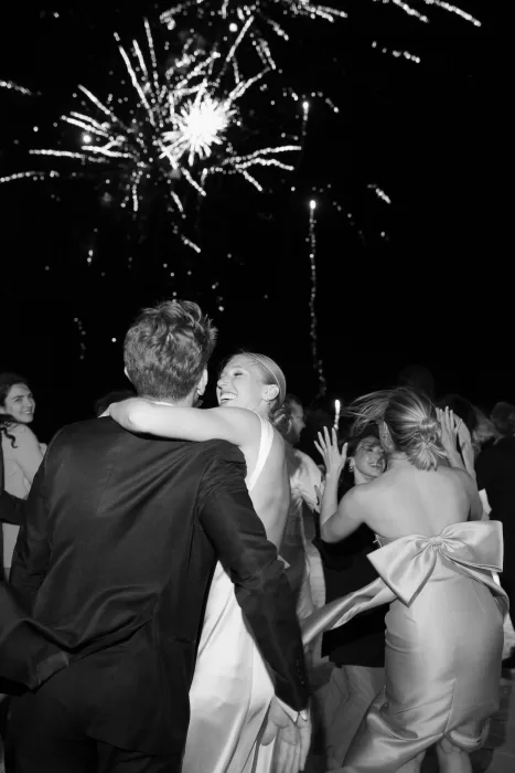 Joyful wedding celebration at Casa Olivi as fireworks light up the night sky behind the couple and their guests.