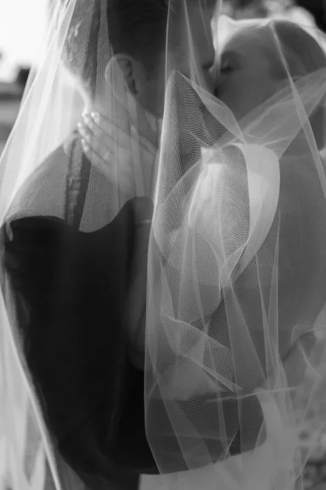 Intimate black and white portrait of the couple kissing under a flowing veil at Casa Olivi.
