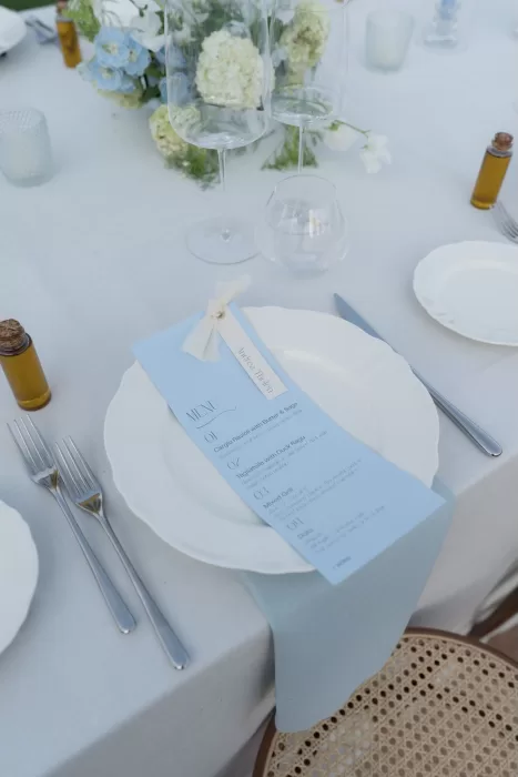 Elegant place setting at Casa Olivi with a pale blue wedding menu and delicate florals.