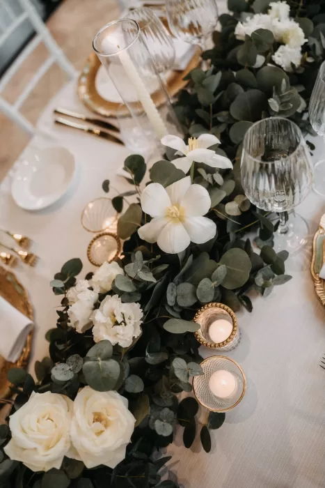 Refined floral table arrangement with white roses and candles at Castello di Casole wedding reception.