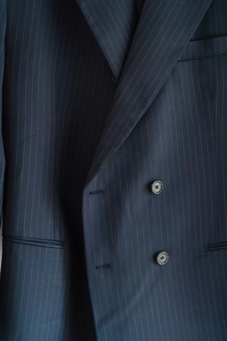 Close-up of the groom’s navy pinstripe suit jacket, ready for the wedding at Castello di Montignano.
