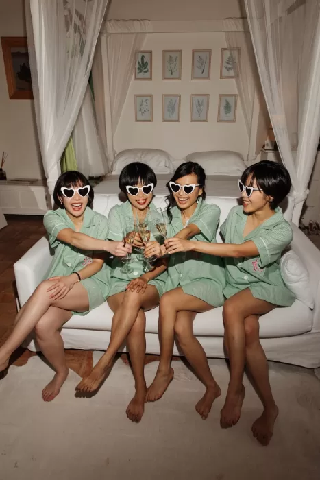 Bridesmaids wearing matching green pyjamas and heart sunglasses celebrating with champagne at Conti di San Bonifacio.