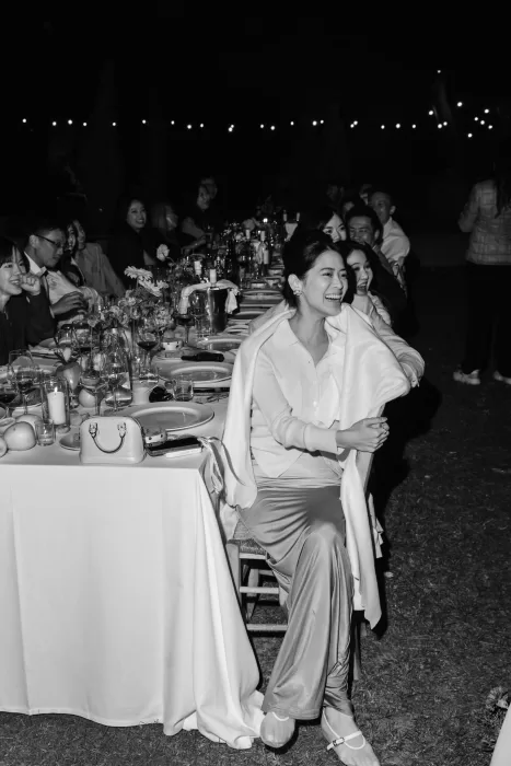 Guests laughing under string lights during an outdoor reception dinner at Conti di San Bonifacio.