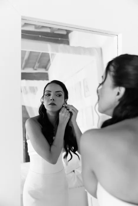 Bride getting ready in front of the mirror at Conti di San Bonifacio, captured in soft black and white.